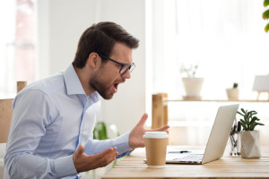 Furious male employee have laptop problems while working